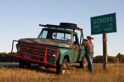 Craig standing next to truck and Ucross population sign